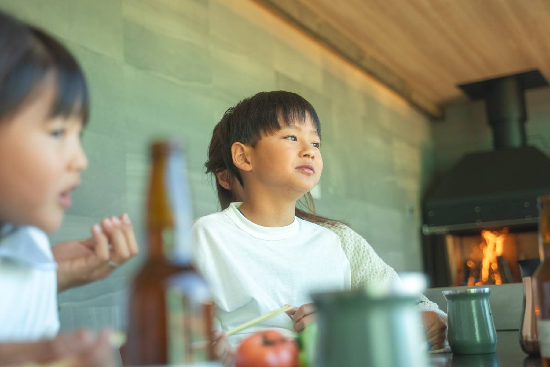 暖炉の前で食事をする子ども